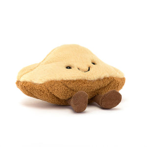 Jellycat brown madeleine shaped plush with a smiling face and brown feet on a white background. 