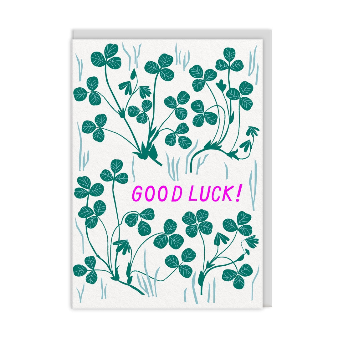 Greeting card with green shamrock design and pink 'Good Luck!' text on a white background.
