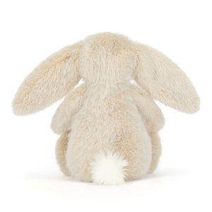 Back view of a Jellycat wheat coloured bunny plush with a white fluffy tail on a white background.