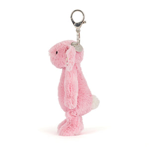 Side view of a pink plush bunny keychain on a white background. The bunny has a white fluffy tail.