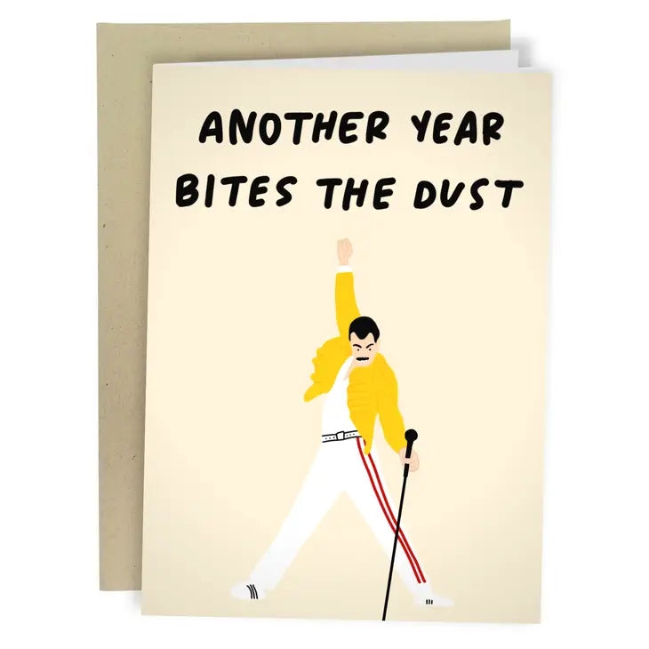 pale yellow birthday card. top text reads "another bites the dust". bottom illustration is a carricature of Freddie Mercury in his iconic Wembley Stadium 1986 yellow-jacket look