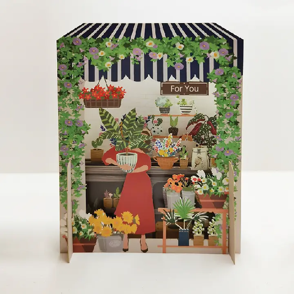 miniature pop up card showing a white woman in a red dress adding a new plant to a plant shop. a sign on the wall of the shop reads "for you"