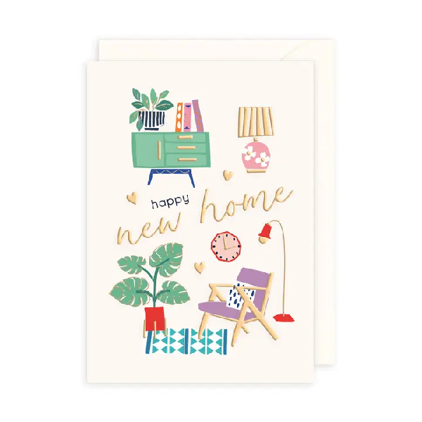 White new home card. Gold text "happy new home" in the middle is framed by cute furniture icons, such as a dresser, lamp, chair, houseplant, and more.