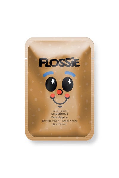 shiny brown rectangular bag with "Flossie" written in black and a cartoonish facial expression at the centre. the flavour of the candy is written in a smaller font below the grimace. the face is remeniscent of a gingerbread man's; blue eyebrows, big black eyes, a red nose, and red cheeks connected by a smile