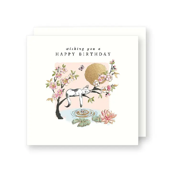 White birthday card. A cat is sleeping on a blooming tree branch above water and lily pads under the text "wishing you a happy birthday".