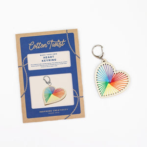 Heart-shaped keyring with a colorful stitched design next to the packaging for a 'Cotton Twist' craft kit on a white background.