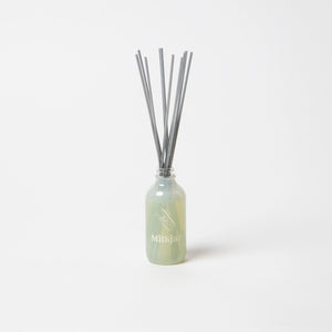Milkjar diffuser bottle containing reed sticks on a white background