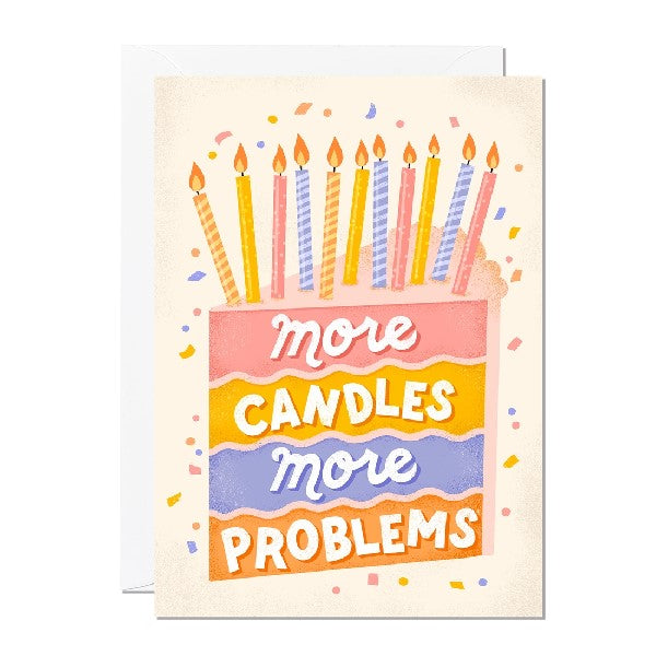 off-white birthday card. pink, orange, purple, and orange layered slice of cake has text that reads "more candles more problems". 11 lit up candles are on the top of the slice