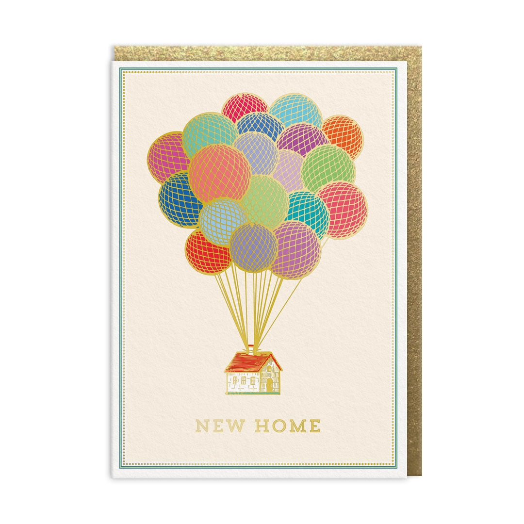 Greeting card with an illustration of  colorful balloons attached to the roof of a house, featuring 'New Home' text on a cream coloured background.