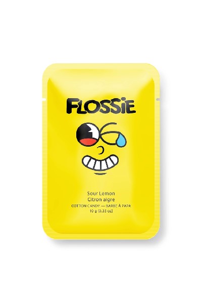 yellow rectangular bag with "Flossie" written in black and a cartoonish facial expression at the centre. the flavour of the candy is written in a smaller font below the grimace.