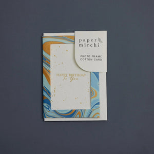 Photo frame cotton card with a blue and gold marbled design and 'Happy Birthday To You' text. The card sits on a blue background. 