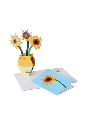 3D pop-up yellow vase model containing three sunflowers on a white background. A greeting card featuring a sunflower on a blue background sits beside the vase. 