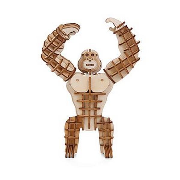 wooden gorilla statuette with raised arms made up of puzzle pieces. kikkerland product on white background