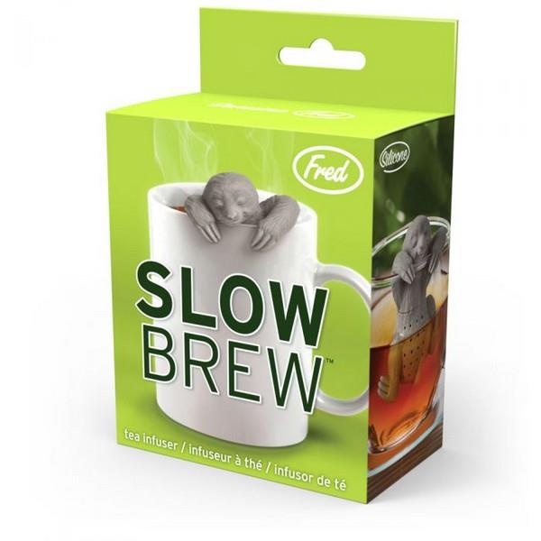 tea infuser in the shape of a grey smiling sloth propping its head and paws above a white cup